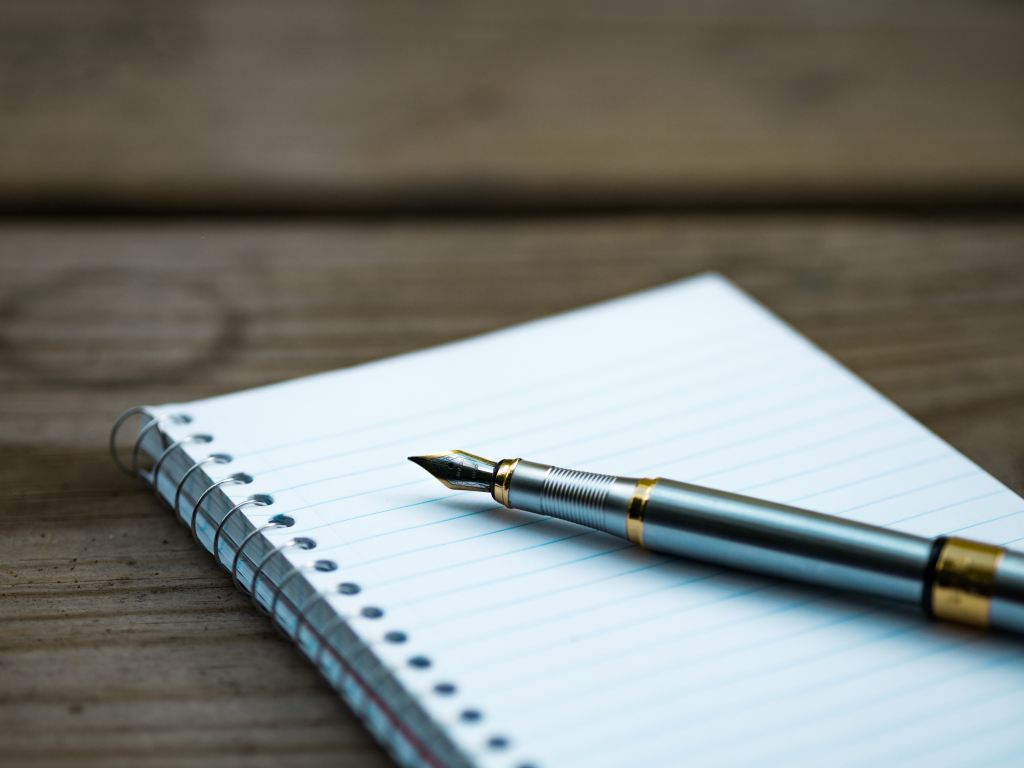 Image of a pen resting on a blocknote and the words "read: 9 dnf: 2 deleted: 7"