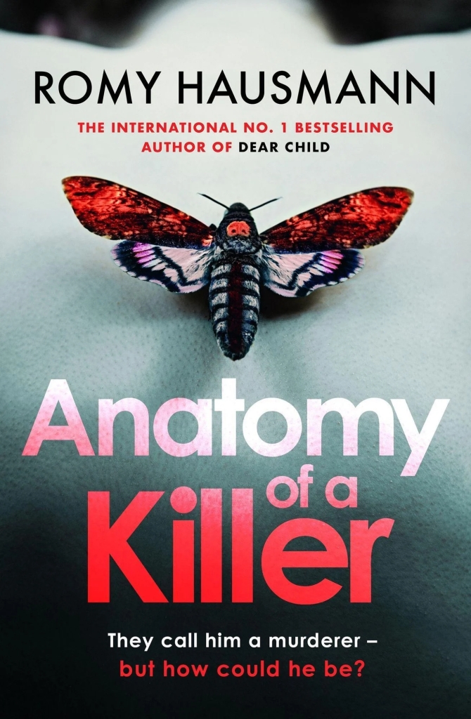 Cover of the book "Anatomy of a Killer", by Romy Hausmann. It shows a close, blurred, and black and white caption of what seem to be the back of a person's shoulders. There is a black and white moth in their middle, and its wings are red.